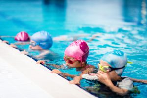 Group of children on swimming class, making bubbles